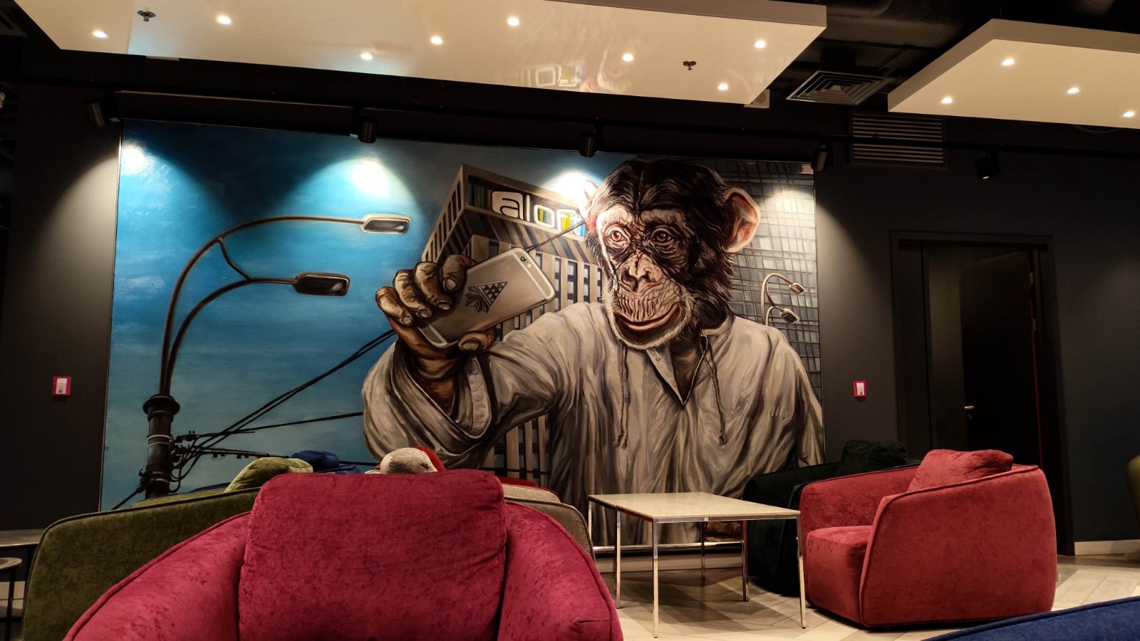Club house. Empty chairs with big wallpager in background showing monkey holding mobile phone